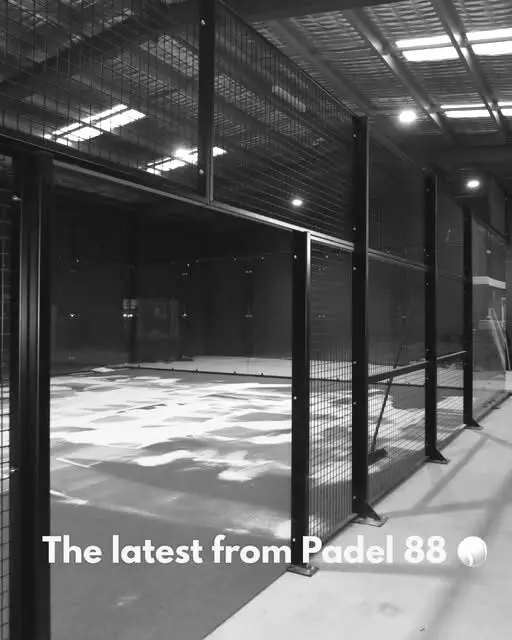 The indoor padel court lit from above, empty and ready to play.